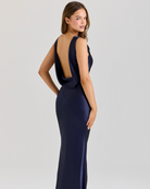 Navy blue evening gown with open back on a white background